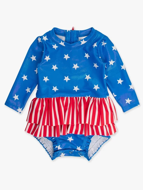 RUFFLEBUTTS SHIMMER STARS & STRIPES LONG SLEEVE SKIRTED RASH GUARD