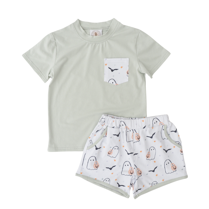 Children's outfit with light green t-shirt and white shorts with ghost pattern on a white background