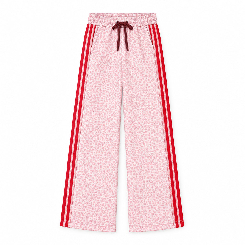 A flat technical drawing of wide-leg pants on a white background, labeled with style code H085890211 and material text reading 'GARDENIA COTTON POLY FLEECE.' The pants are light pink with a dense small floral print and bold red side stripes, plus a dark red drawstring at the waist.