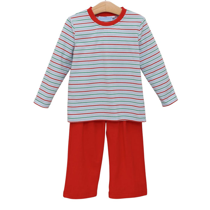 A two-piece children's pajama set on a wooden hanger, featuring a long-sleeve top with thin red and dark blue horizontal stripes on a white background, and solid red pants.