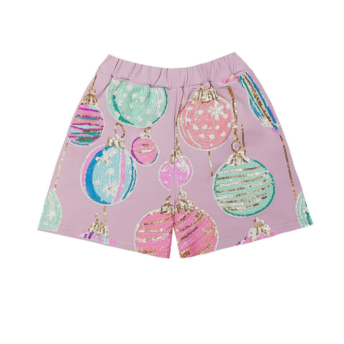 A pair of girls' shorts in lavender pink, decorated with a festive sequin Christmas ornament print in pink, mint green, and blue, set against a plain white background.