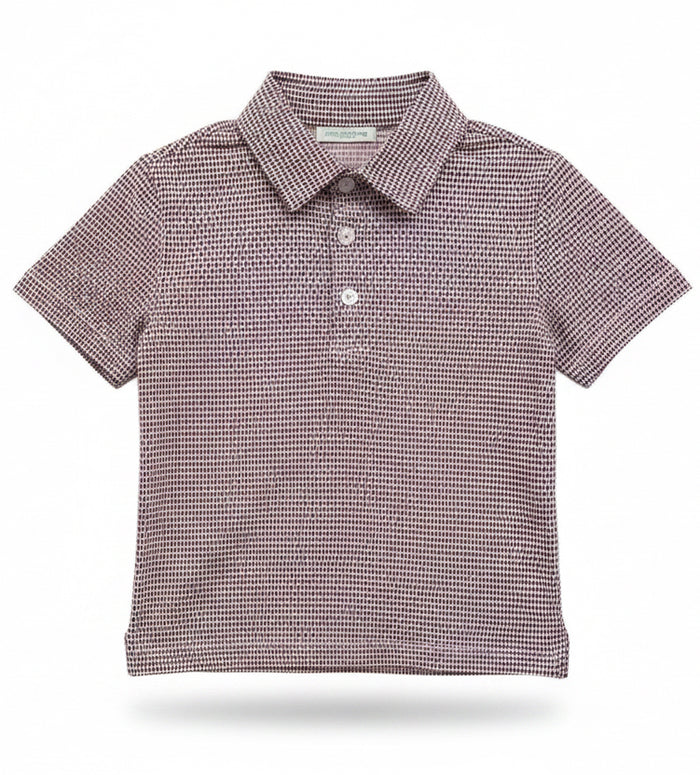 A short-sleeve polo shirt with a fine black and white micro-pattern, hanging on a clear plastic hanger against a white wire retail display grid.