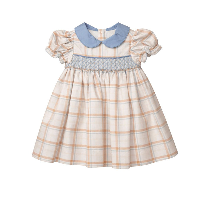 A toddler girl's dress with a cream and peach plaid pattern, featuring a light blue Peter Pan collar and a matching smocked waistband.