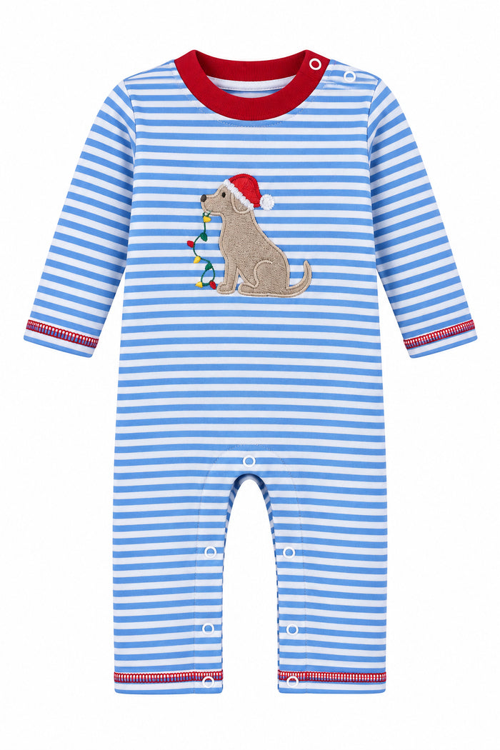 A baby long-sleeve romper with blue and white horizontal stripes, featuring a gray dog applique wearing a red Santa hat on the chest. The romper is displayed on a hanger in a retail store setting with shoe boxes stacked behind it.