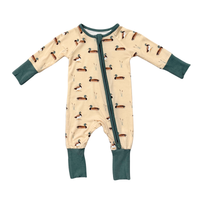 A baby long-sleeve footless sleeper with a front zipper, featuring a cream background with a repeating duck print and dark teal cuffs, collar, and leg bands.
