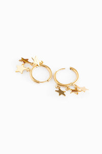 Gold hoop earrings with star charms on a white background
