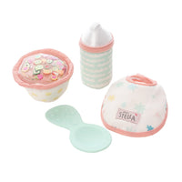 Set of baby accessories including a bib, cup, and bottle on a white background