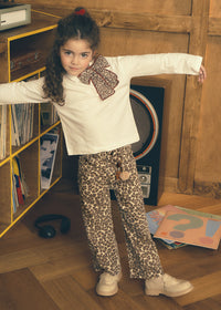 Young girl in a room with a bookshelf and toys on the floor