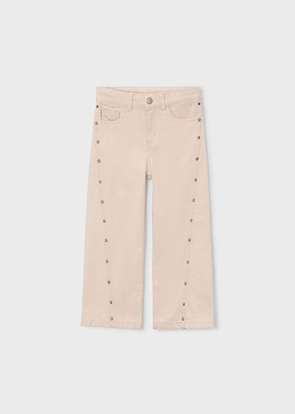 Beige pants with button details on a white background