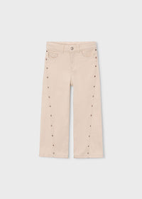 Beige pants with button details on a white background