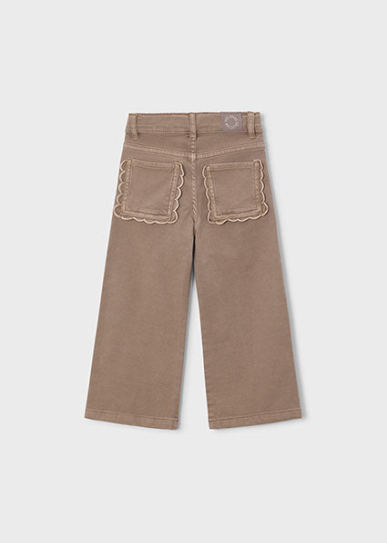 A pair of wide-leg cropped pants in a warm taupe-brown color, shown from the back. The back pockets feature a distinctive scalloped edge and matching scalloped embroidery.