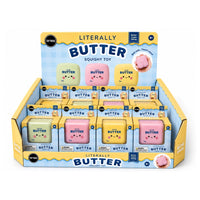 A retail display box filled with individually packaged Butter Squishy Toys. The display is yellow and blue, showing six colorful squishy toys in pastel shades of green, pink, and yellow, each with a cute face.