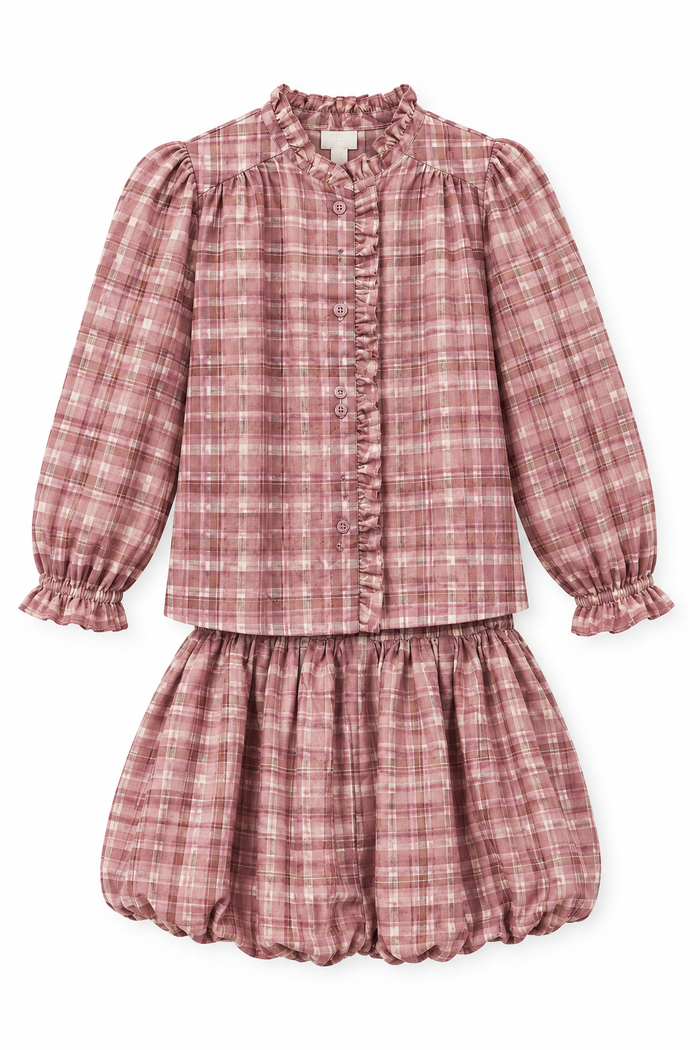 A two-piece girls' outfit in a dusty rose and pink plaid fabric, featuring a long-sleeve button-front blouse with ruffle trim and a matching ruffled skirt, shown on a plain white background.