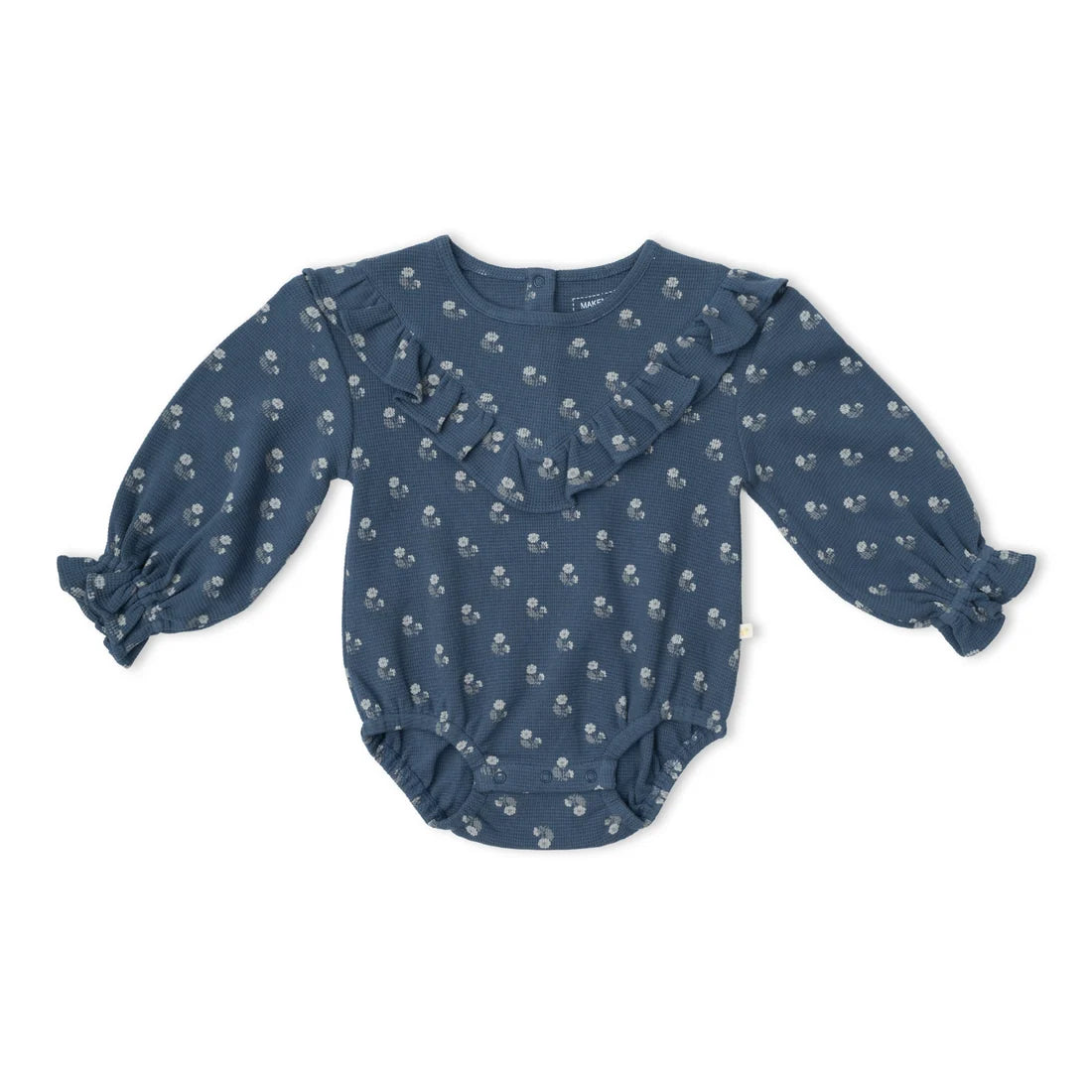 A baby long-sleeve romper in dusty blue with a small white floral print, featuring ruffle details on the chest and cuffs, laid flat on a white background.