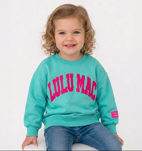 Child wearing a teal sweatshirt with 'LULU MAC' in pink text on a white background