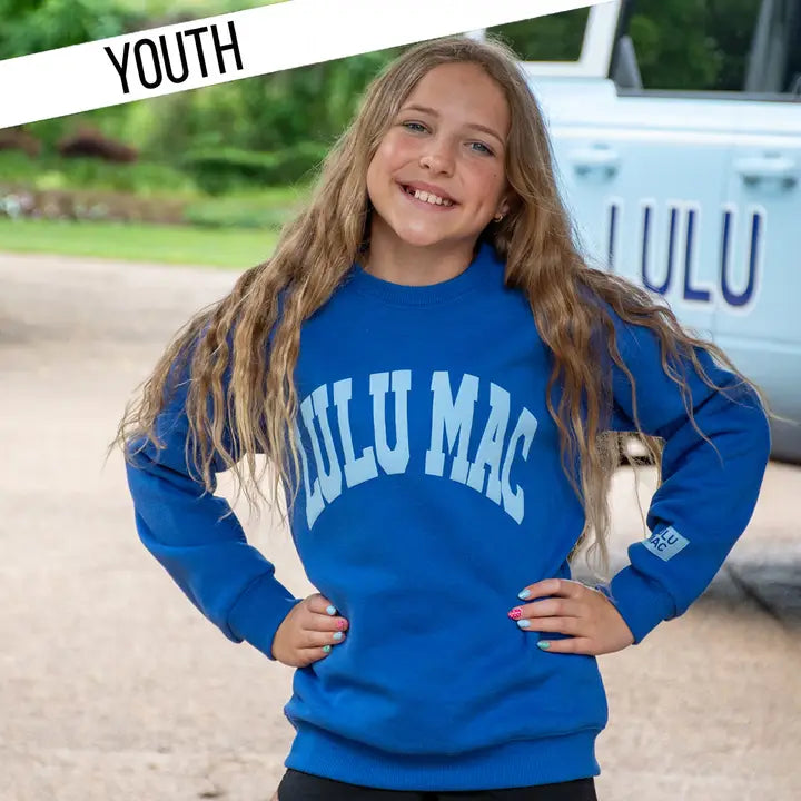 Girl wearing a blue 'LULU MAC' sweatshirt with a vehicle in the background