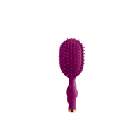 A purple oval hairbrush with a twisted handle and a small gold accent at the base, shown against a plain white background.
