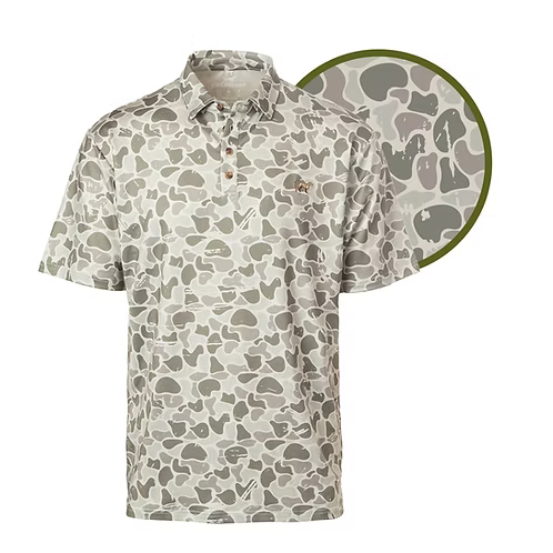 A short-sleeve button-up shirt with an all-over irregular camouflage pattern in beige, gray, and olive green, shown on a white background with a circular inset highlighting the pattern detail.