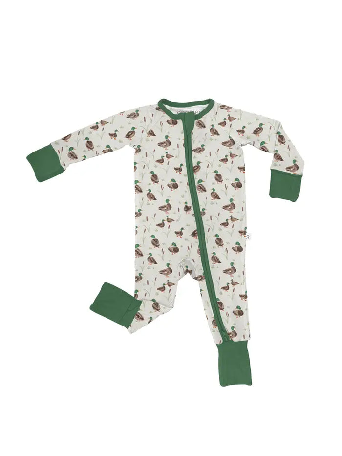 A baby long-sleeve footed sleeper with an all-over duck print on an off-white background, featuring solid green cuffs, collar, and zipper trim.