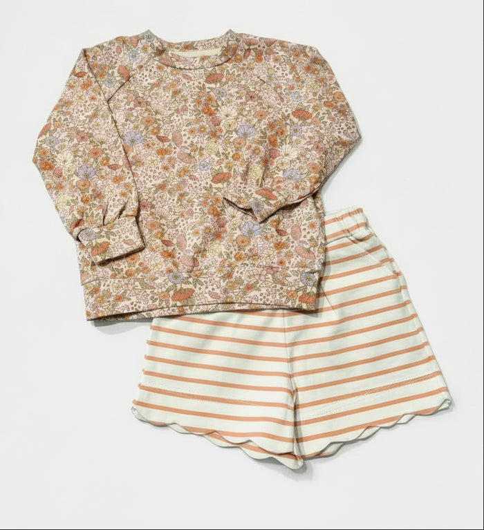 A two-piece children's outfit set featuring a long-sleeve crewneck sweatshirt with an all-over floral print in muted orange, green, and beige tones, paired with matching shorts that have horizontal light blue and orange stripes.
