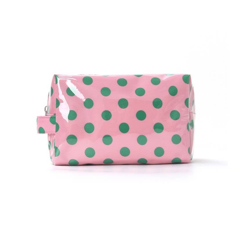 Pink toiletry bag with green polka dots on a white background