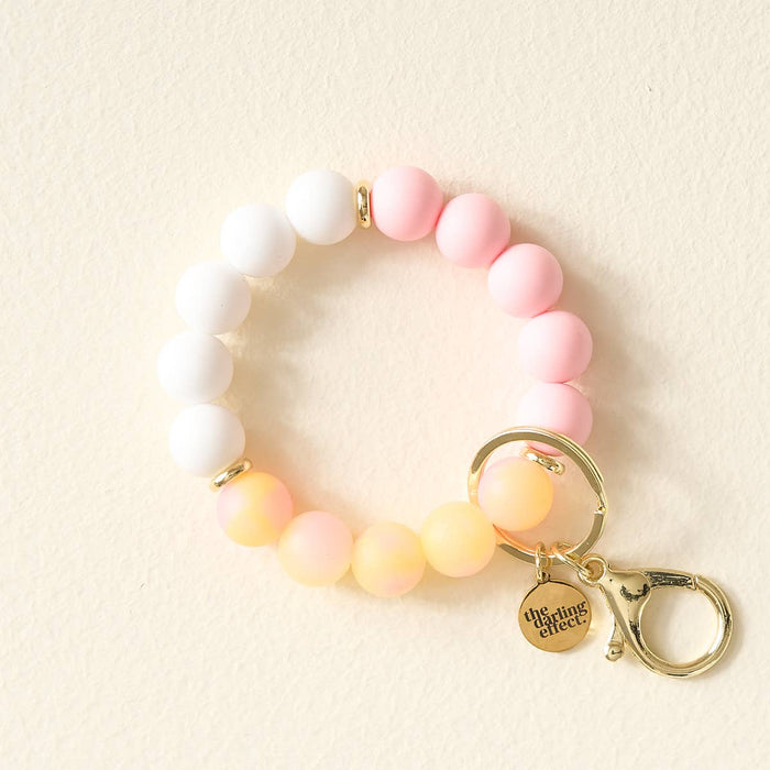 Beaded bracelet with a keychain on a beige background