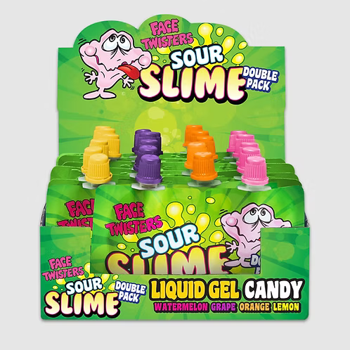 A retail display box of Sour Slime Face Twisters Liquid Gel Candy, showing multiple small green packets with yellow, purple, orange, and pink caps. The packaging features a cartoon pink slime character and text indicating watermelon, grape, orange, and lemon flavors.