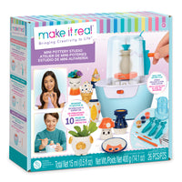 Make It Real Mini Pottery Studio kit in its retail packaging, featuring a light blue and white electric potter's wheel with a clear dust cover, various colorful clay tools, small sculpting pots, and printed instructions and example works on the box front.