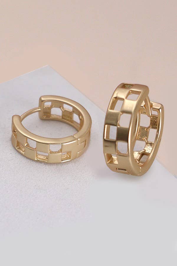Gold hoop earrings on a light beige background