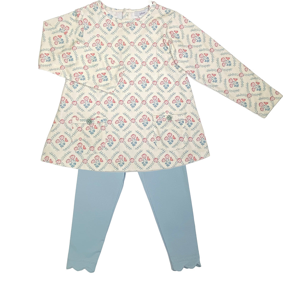 Children's outfit with patterned top and light blue pants on a white background