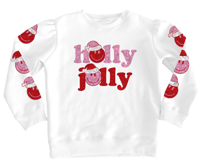 A white long-sleeve crewneck sweatshirt featuring 'holly jolly' printed on the front in pink and red glitter-textured lettering with Santa hats, and matching Santa graphics printed down both sleeves.