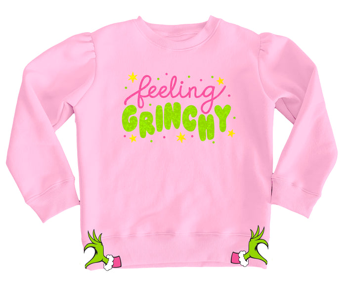Pink sweatshirt with 'feeling Grinchy' text and Grinch hands on a white background