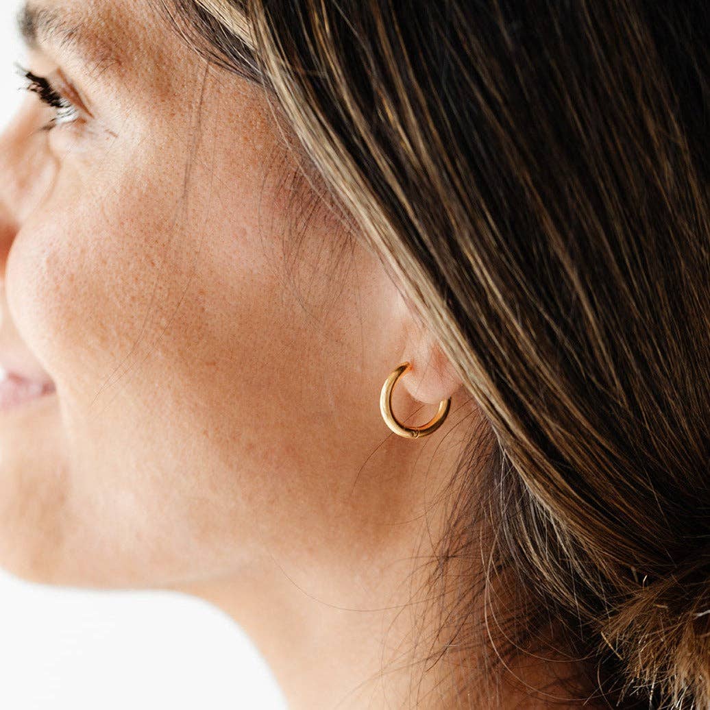 Close-up of a woman wearing a gold hoop earring.