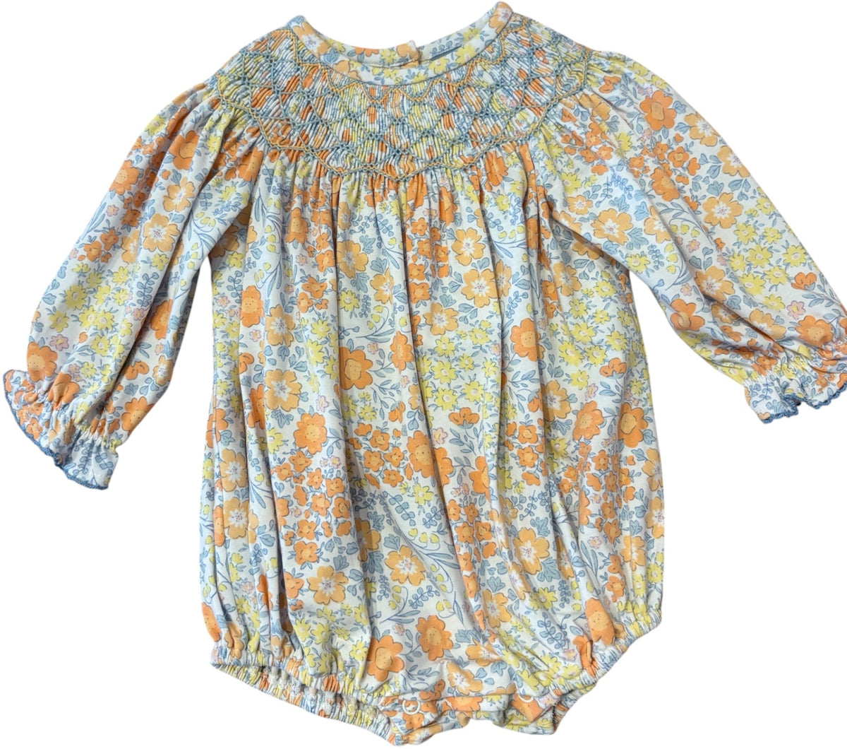 A baby girl's long-sleeve romper with a smocked bodice and a blue, yellow, and orange floral pattern, shown against a plain white background.