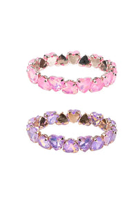 Two heart-shaped crystal stretch bands, one in pink and one in lavender purple, set in rose gold-toned metal, displayed on a clean white background.