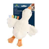 Itzy Huggable plush duck toy with a soft cream body, orange beak and feet, and small colorful fabric tabs on the wing, shown on its branded retail card against a white background.