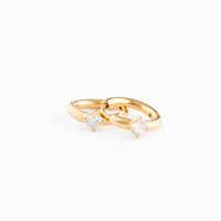 Gold ring with two small diamonds on a white background