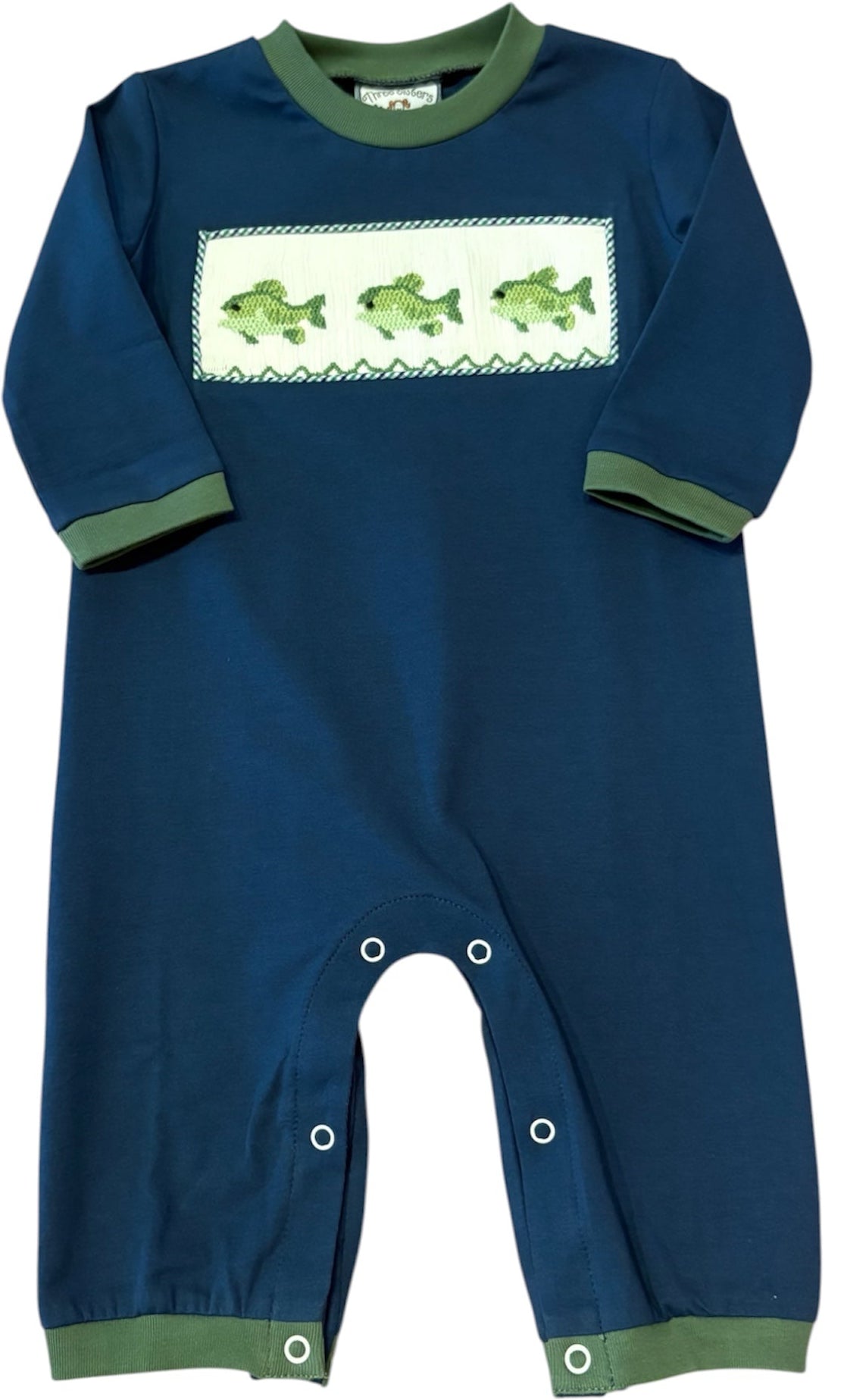 A navy blue baby jumpsuit with sage green trim on the collar, cuffs, and ankles, featuring a white rectangular chest panel with three green fish illustrations.