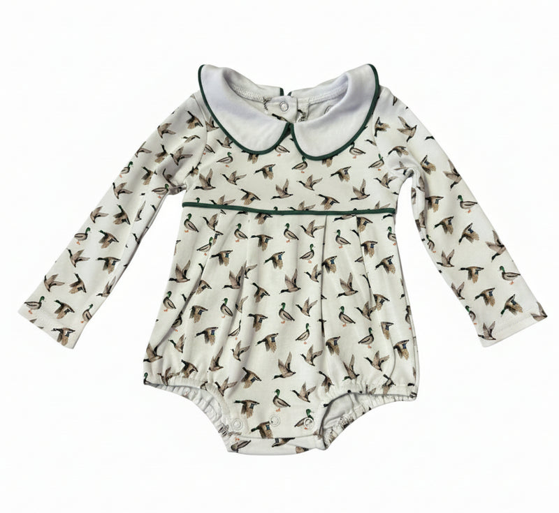 Baby long-sleeve romper in off-white with an all-over duck print, featuring a white Peter Pan collar with dark green trim and a matching green waistband.