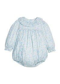 A baby long-sleeve romper in a light blue and white floral print, featuring a ruffled collar, smocked bodice, and elasticized bubble sleeves and leg cuffs.