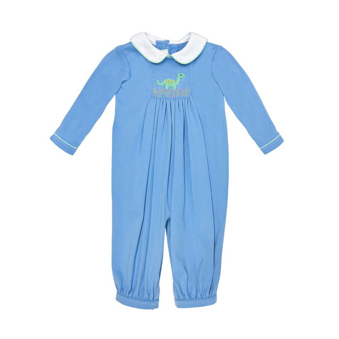 A baby's long-sleeve footless jumpsuit in light blue, featuring a white faux-fur Peter Pan collar, white piping on the cuffs, and a smocked chest design with a green dinosaur and gold pattern.