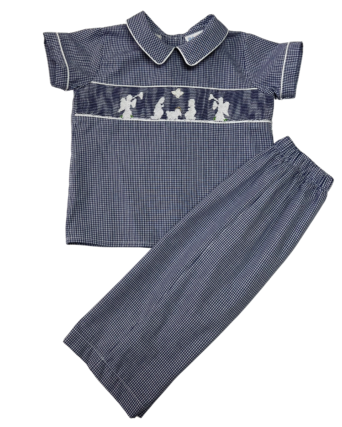 A two-piece boys' pajama set featuring a short-sleeve collared shirt and matching pants in a navy and white micro-check pattern. The shirt has a smocked chest panel with white embroidered figures.