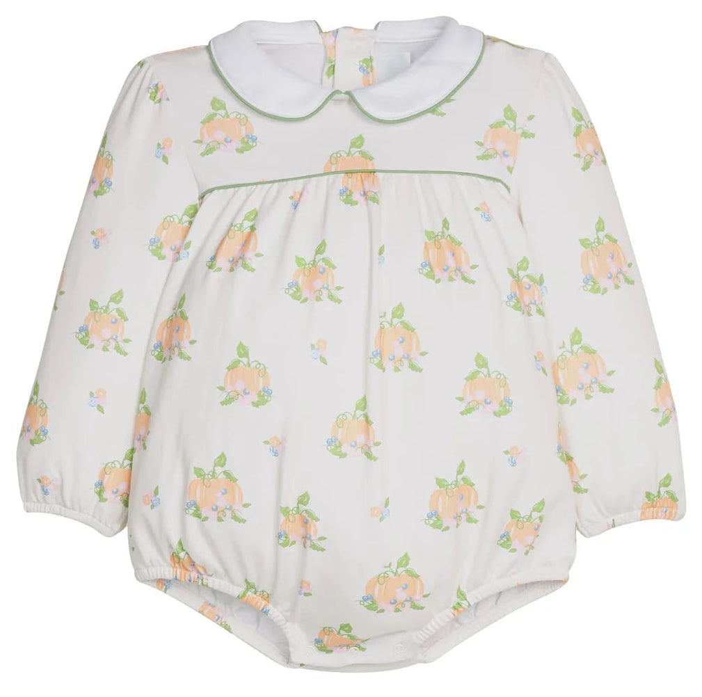 A baby long-sleeve romper in off-white with a repeating print of peach-colored pumpkins with green leaves. It features a white Peter Pan collar and a thin green piping detail across the chest.