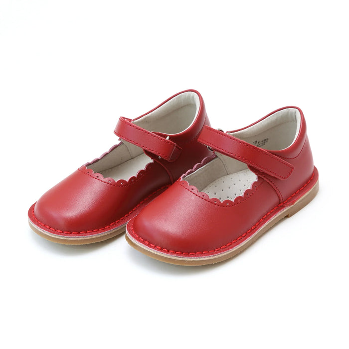 Pair of red children's shoes with a strap on a white background