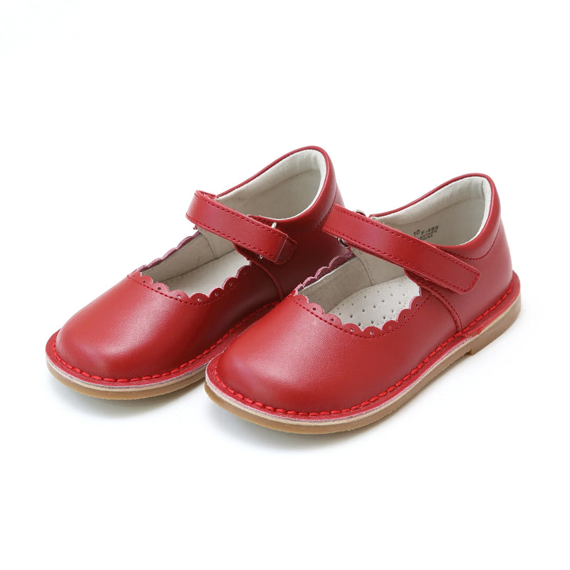 Pair of red children's shoes with a strap on a white background