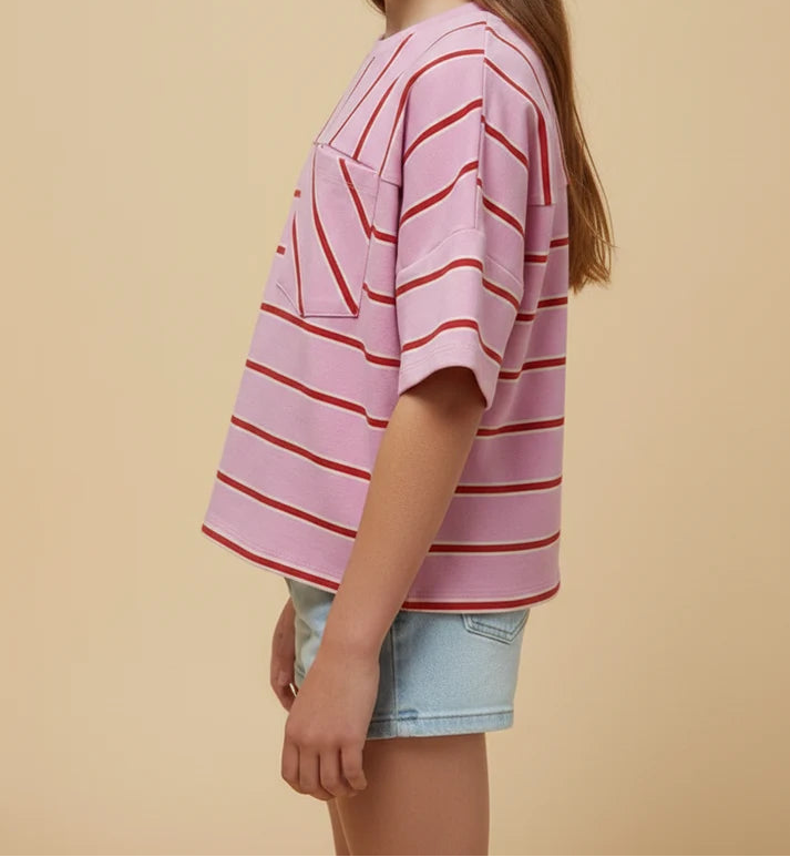 Young girl wearing a pink and red striped shirt against a beige background