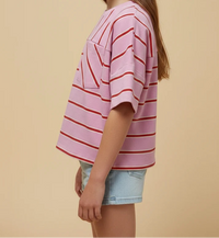 Young girl wearing a pink and red striped shirt against a beige background