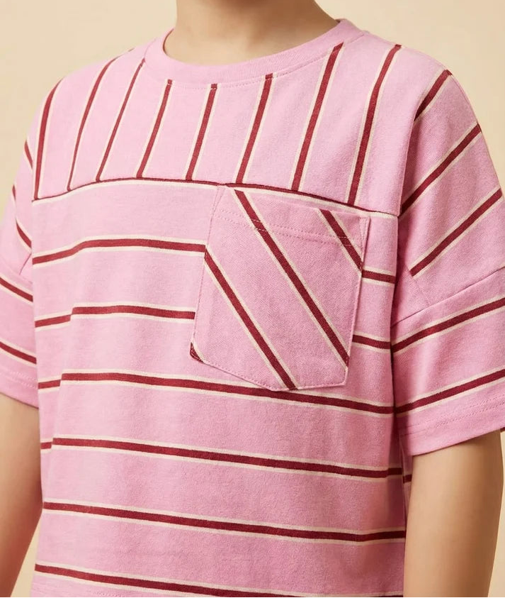 Child wearing a pink and red striped shirt with a pocket on a beige background