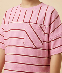 Child wearing a pink and red striped shirt with a pocket on a beige background