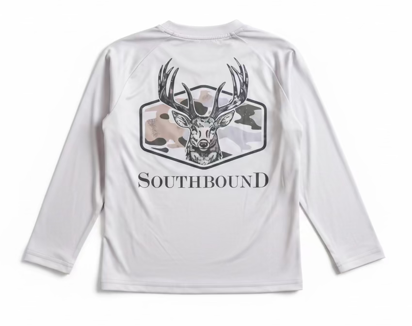 A white long-sleeve raglan shirt with a large graphic of a deer head and the word 'SOUTHBOUND' on the back, held up by a hand in a retail or storage room setting.